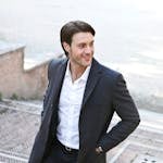Man in White Dress Shirt and Black Blazer Standing Outside Building